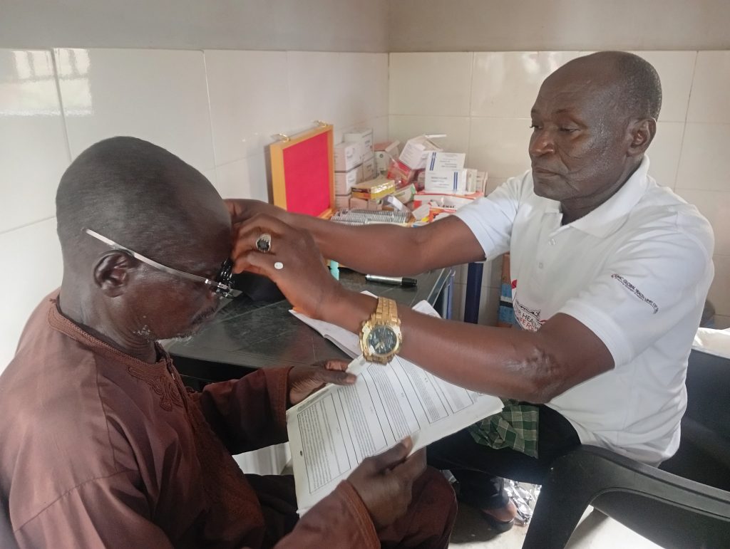 Dr. Mark Tukur, Lead of the Nigeria Episcopal Area Medical Team, attends to a patient with an eye-related condition during the medical outreach